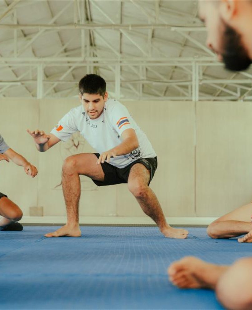 Alumnos entrenando en círculo sobre el tatami azul en Quillabamba Fighter