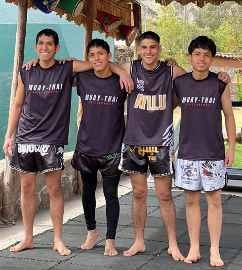 Alumnos de Quillabamba Fighter abrazados en el tatami bajo el techo del gym