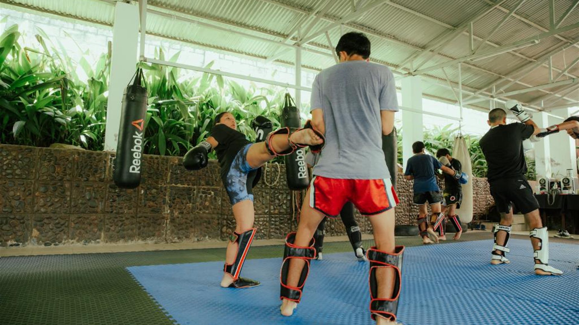 Alumna practicando patada circular en sparring en Quillabamba Fighter