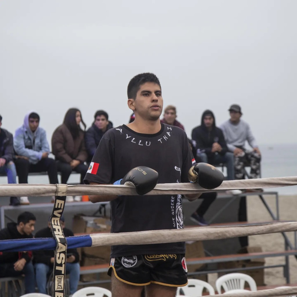 Luchador de Muay Thai de Quillabamba Fighter en el ring, con guantes y shorts de competencia